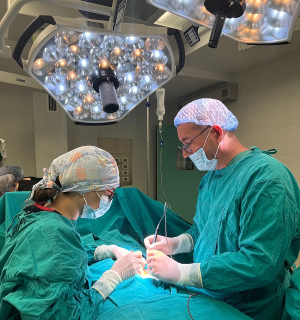 Doktor - proktolog i sestra u operacionoj sali operišu pacijenta.